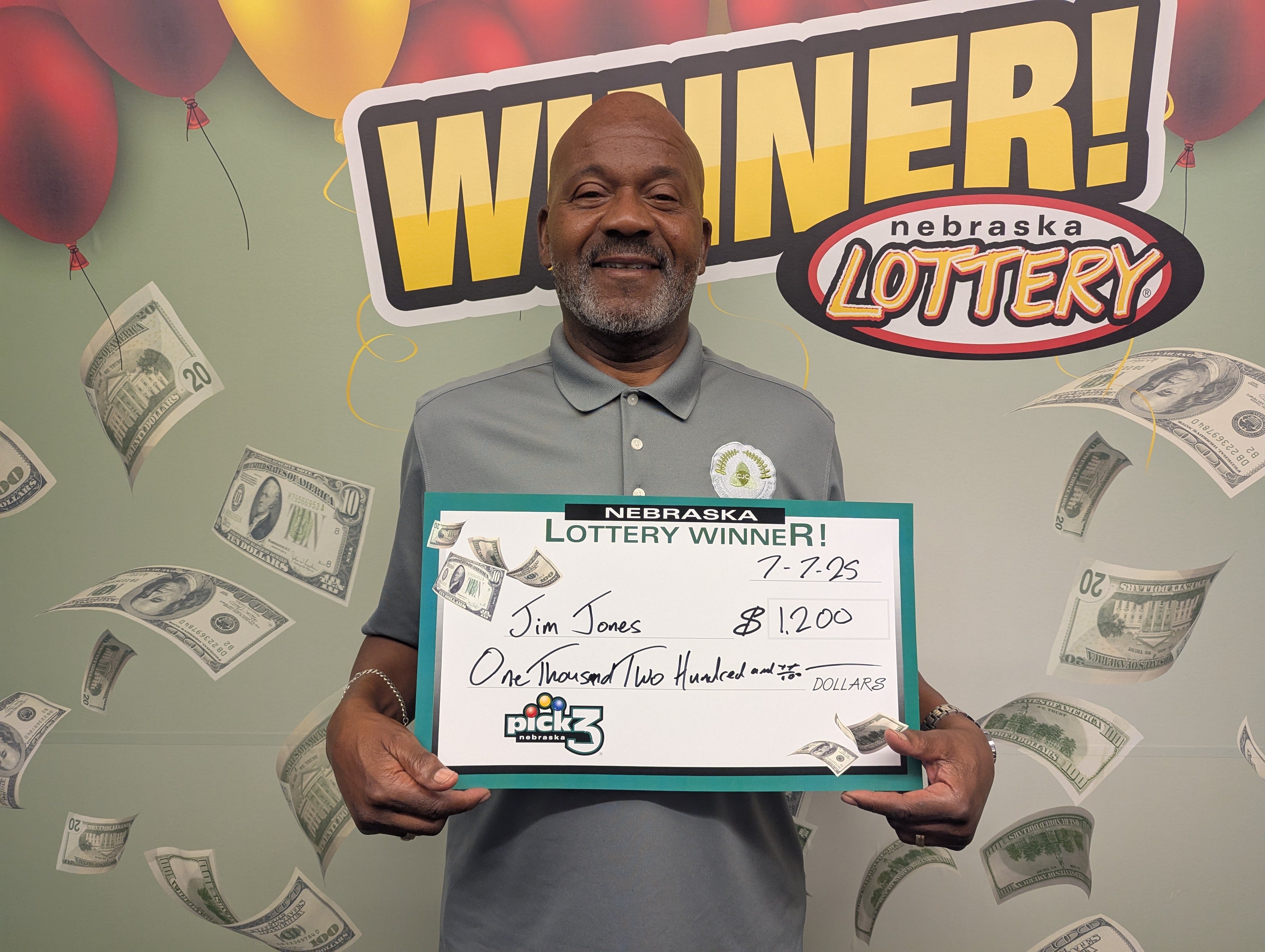 Jim Jones of Lincoln stands with his $1,200 check at Nebraska Lottery headquarters. 